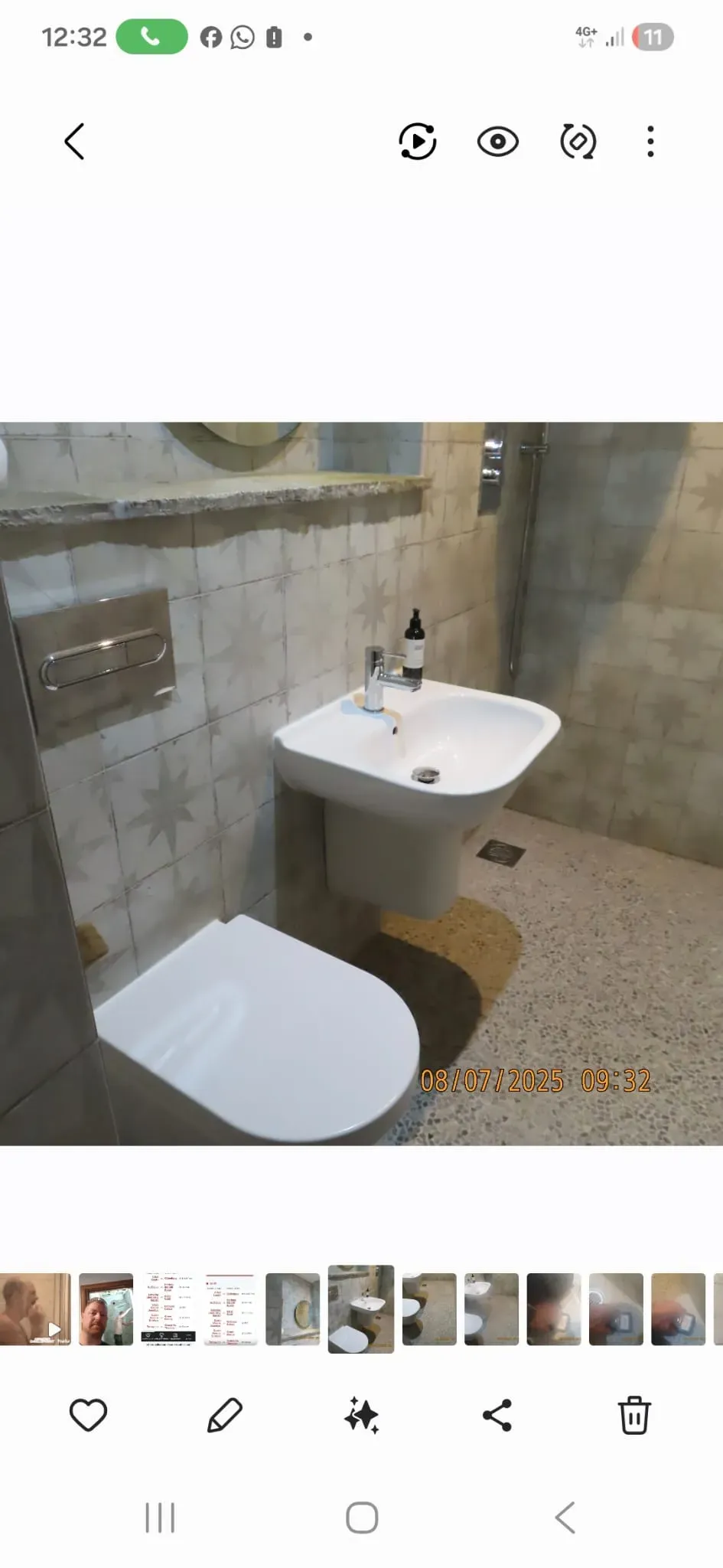 Modern bathroom refurbishment with a wall-mounted toilet, pedestal sink, tiled walls and floor, and a shower.